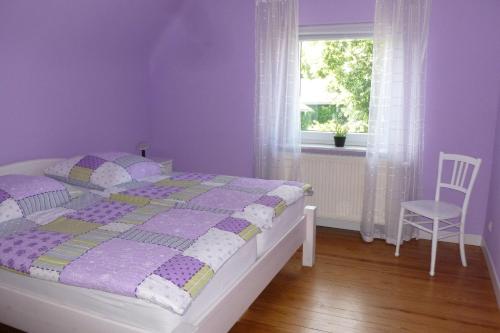 a purple bedroom with a bed and a window at Ferienwohnung Sommer in Sankt Wendel