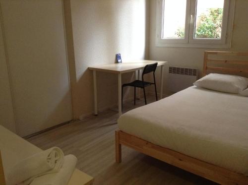 une chambre avec un lit, un bureau et une table dans l'établissement Résidence le Pastel François Verdier, à Toulouse