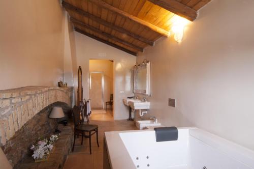 a bathroom with a stone fireplace and a sink at Masseria Celentano Relais & Agriturismo in San Severo