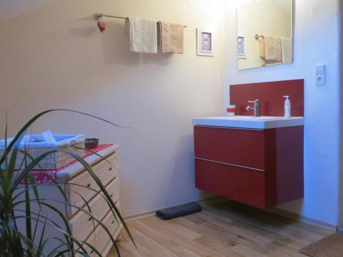 a bathroom with a red sink and a mirror at Pension Marianne - Chiemgau Karte in Inzell