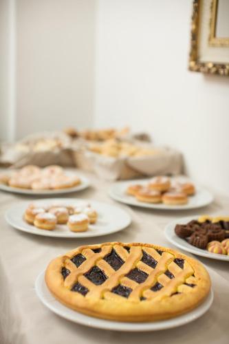 a table topped with plates of different types of pastries at Hotel Europa in Modena