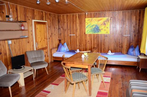 a room with two beds and a table and chairs at Bungalow Pipp in Passriach