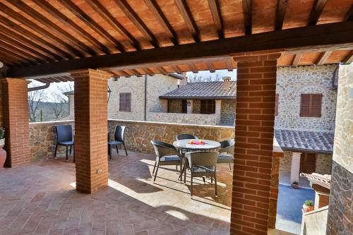 a patio with a table and chairs under a wooden pergola at Borgo Poggiardelli in Montepulciano