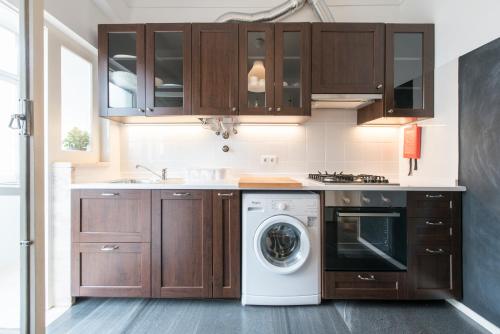 a kitchen with wooden cabinets and a washer and dryer at Beautiful view close to Estádio da Luz in Lisbon