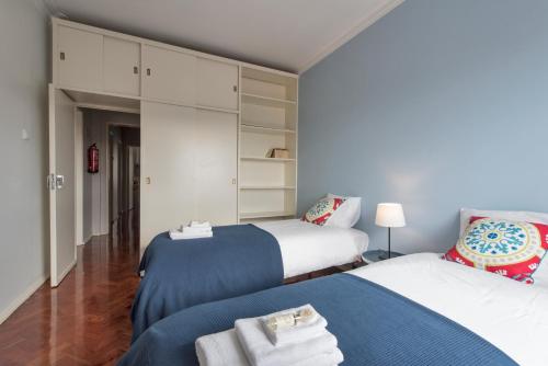 a bedroom with two beds and a chair in it at Beautiful view close to Estádio da Luz in Lisbon