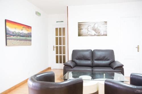 a living room with a leather couch and a table at Rey Fernando in Santiago de Compostela