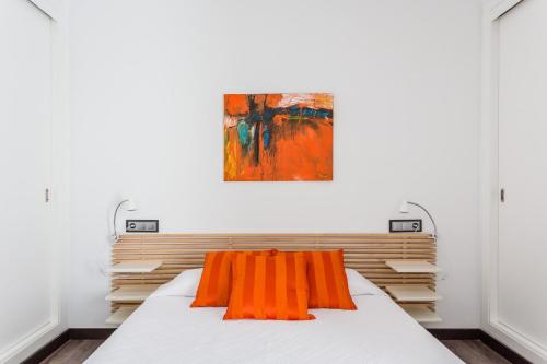 a bedroom with a bed with an orange pillow on it at Ca Sa Padrina by LOCALITE in Can Picafort