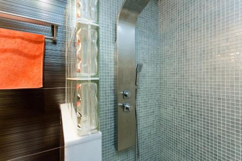 La salle de bains est pourvue d'une douche et de murs carrelés bleus. dans l'établissement Ca Sa Padrina by LOCALITE, à Can Picafort