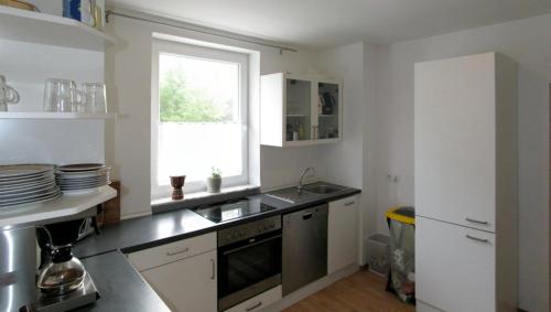 a kitchen with a sink and a window at Gästehaus Perrin in Bliesmengen-Bolchen