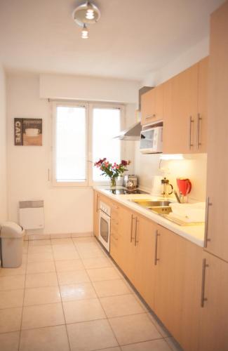 d'une cuisine avec des placards beiges, un évier et une fenêtre. dans l'établissement Palais Alexandra, à Antibes