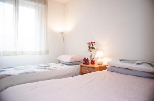 deux lits dans une chambre blanche avec une fenêtre dans l'établissement Palais Alexandra, à Antibes