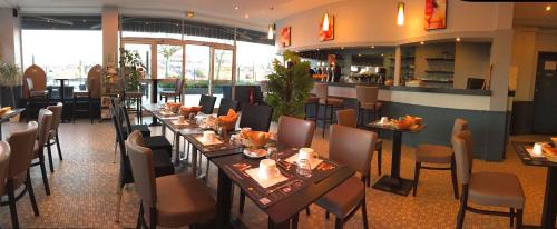 une salle à manger avec des tables et des chaises dans un restaurant dans l'établissement Le Pavillon, à Blois