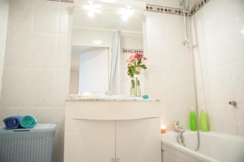 une salle de bain avec un lavabo et un vase de fleurs dans l'établissement Palais Alexandra, à Antibes