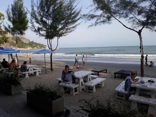 a group of people sitting at picnic tables on the beach at Ban View Viman Condo in Hua Hin