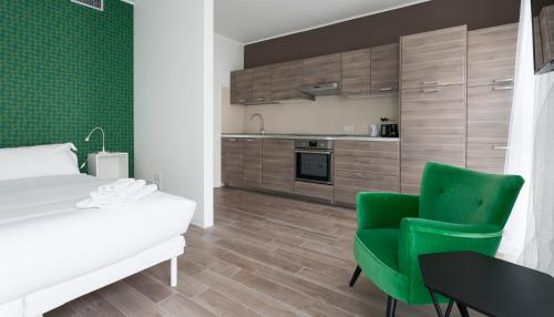 ミラノにあるItalianway-Pomaのベッドルーム1室(ベッド1台、緑の椅子2脚付)