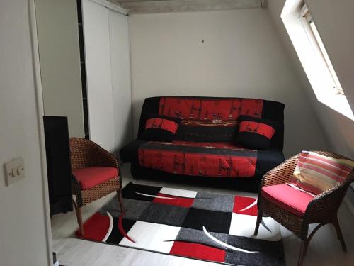 a living room with a red couch and two chairs at Cosy Holidays Room in Paris