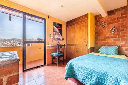 a bedroom with a bed and a desk and a window at Hostal Casa de Dante in Guanajuato