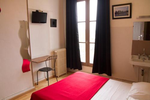 a bedroom with a red rug and a window at Le Pavillon in Blois
