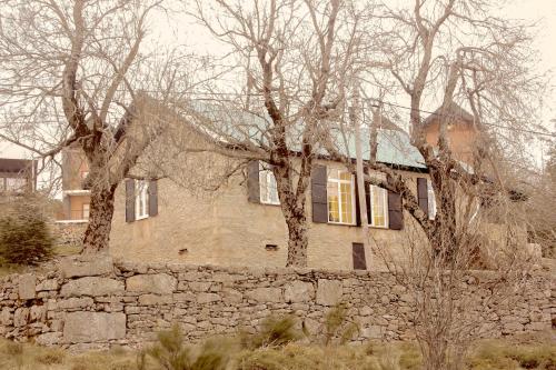 a stone house with two trees in front of it at Mountain House/ Serra da Estrela in Penhas da Saúde