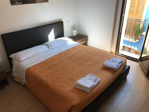 a bedroom with a large bed with two towels on it at Mario Al Borgo in San Benedetto del Tronto