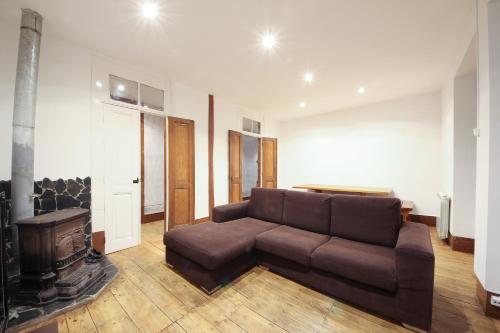a living room with a brown couch and a fireplace at Mountain House/ Serra da Estrela in Penhas da Saúde