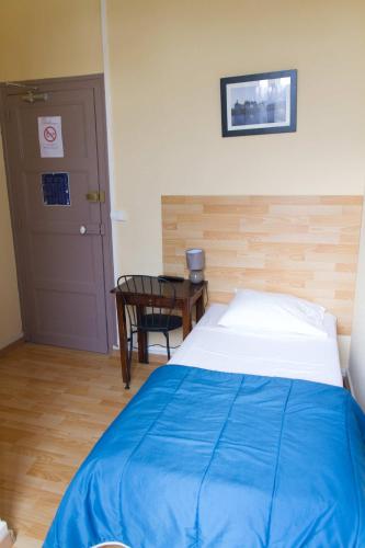 a bedroom with a bed and a table and a door at Le Pavillon in Blois