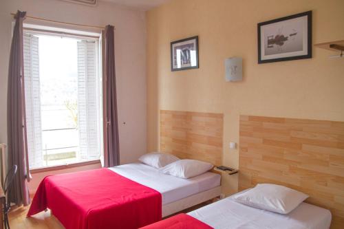 two beds in a room with a window at Le Pavillon in Blois