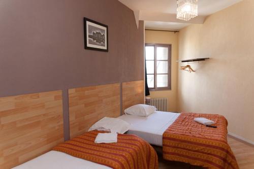 a bedroom with two beds and a window at Le Pavillon in Blois