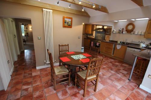 a kitchen with a table and chairs in a room at Wishing Well Cottage in Wilmington