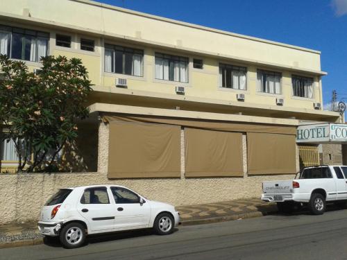 dos autos blancos estacionados frente a un edificio en Hotel Columbia Palace, en Pirassununga