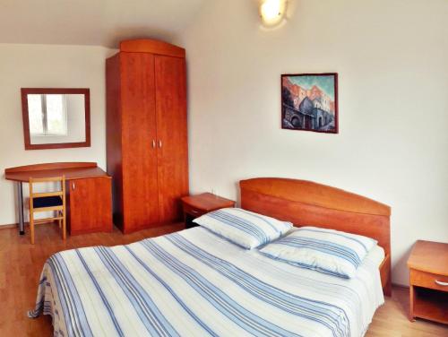a bedroom with a bed and a cabinet and a table at Luka Kokić Apartments in Podgora