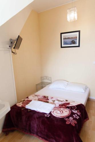 a bedroom with a bed with a purple blanket at Le Pavillon in Blois