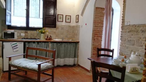 a kitchen with a table and a sink and a table and chairs at Agriturismo Spazzavento in Palazzone