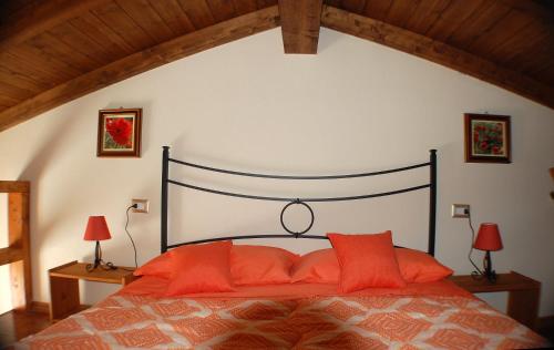 a bedroom with a large bed with orange pillows at La casetta di MrBee in Iglesias