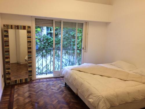um quarto com uma cama e uma grande janela em Guatemala em Buenos Aires