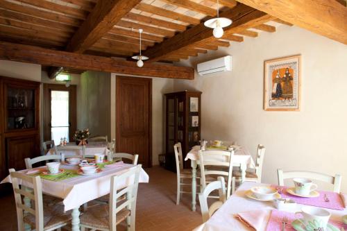 a dining room with white tables and white chairs at Casale Talevi in Cartoceto