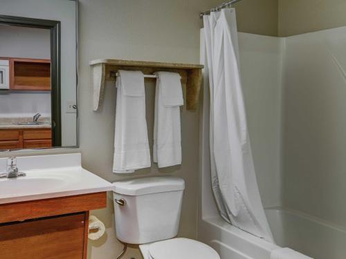 een badkamer met een toilet, een wastafel en een douche bij WoodSpring Suites Junction City in Junction City