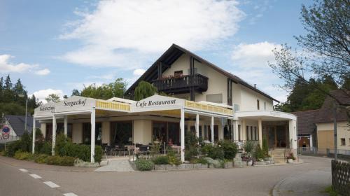 a white building with a balcony on a street at Seegasthof Franz Bolz GBR in Ellwangen