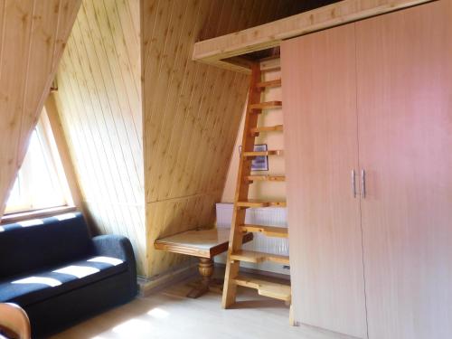 a room with a staircase and a couch in a cabin at Willa pod piórem in Szczyrk