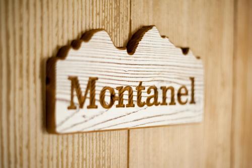 a sign on a wooden wall with the word nomamed at Dimora Al Bivacco in Pieve di Cadore