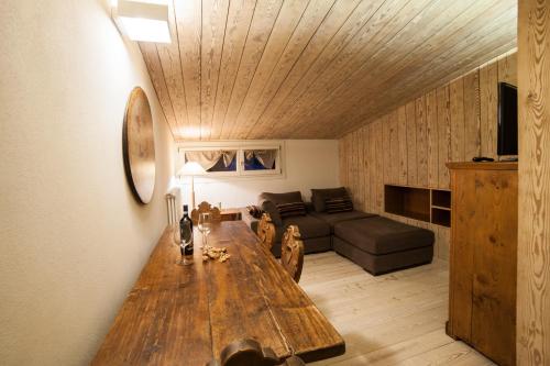 a living room with a wooden table and a couch at Dimora Al Bivacco in Pieve di Cadore
