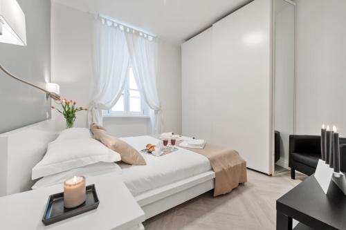 a white bedroom with a bed and a desk at Trevi Apartment in Rome