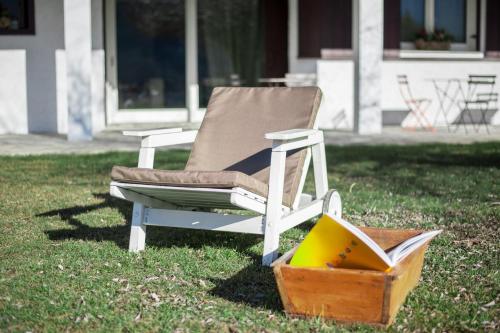 a chair sitting in the grass with a box at Dimora Al Bivacco in Pieve di Cadore