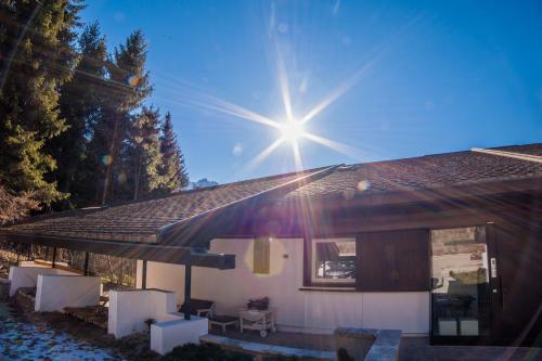 a house with the sun shining on the roof at Dimora Al Bivacco in Pieve di Cadore