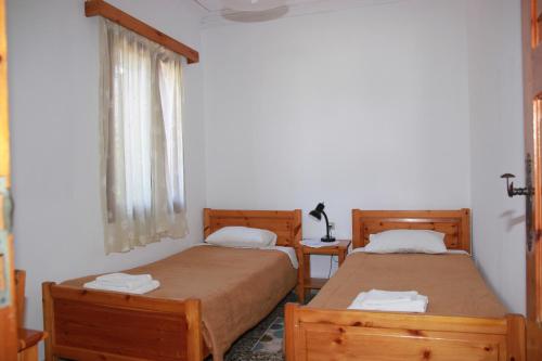 two beds in a small room with a window at Tasos Cottages in Gerani Chanion