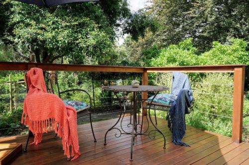 two chairs and a table on a wooden deck at Little Violet in Belgrave