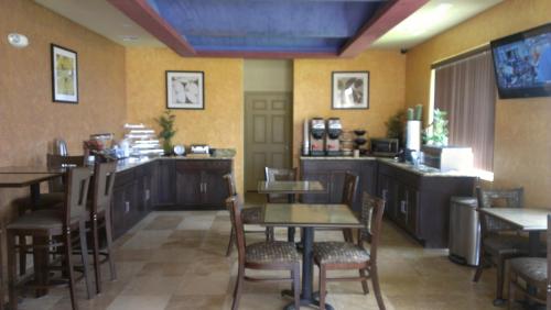 Pearsall Inn and Suites في Pearsall: مطعم بطاولات وكراسي وبار