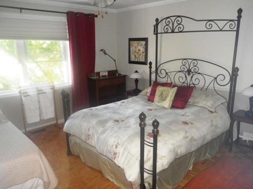 Schlafzimmer mit einem Bett mit schwarzem Rahmen in der Unterkunft Gîte Maison Parc Delormier in Trois-Rivières