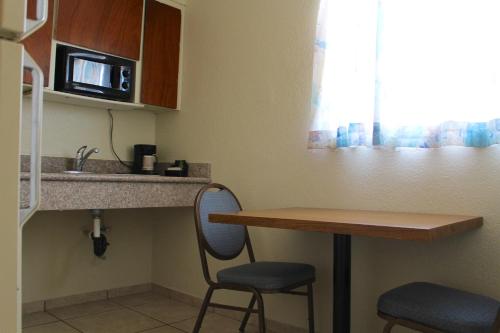a small kitchen with a counter and a table and chairs at Starlite Motel in Mesa