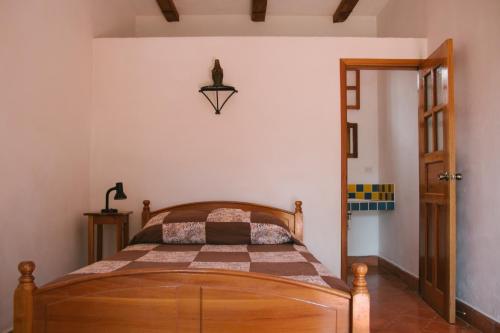 1 dormitorio con cama de madera en una habitación en La Casa de Cafe Bed and Breakfast, en Copan Ruinas